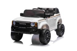 Elektrisches Kinderauto Toyota Landcruiser 12V, weiß, breiter Einzelsitz, 2,4 GHz Fernbedienung, USB-/AUX-Eingang, Bluetooth, Federung, Lithiumbatterie, LED-Lichter, 2 x 25W Motor, ORIGINAL-Lizenz